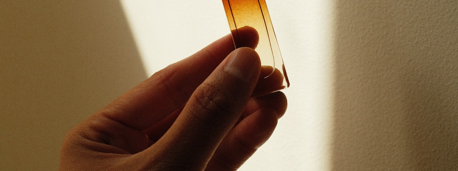 HUUE Fragrance Oil Roll-On held up to light